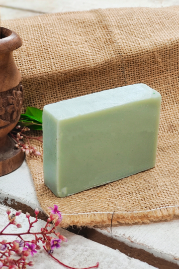 Natural green rectangular soap bar by Almitra Sustainables shown lying flat on jute cloth, surrounded by eco-friendly decor and herbs – handmade, sustainable, chemical-free skincare product.