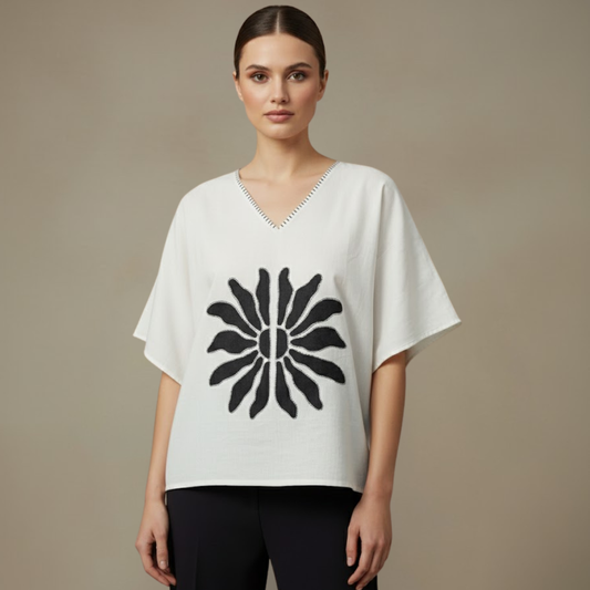 Woman wearing a Mangalagiri Cotton Anti-Fit white top with a black floral design on a beige background