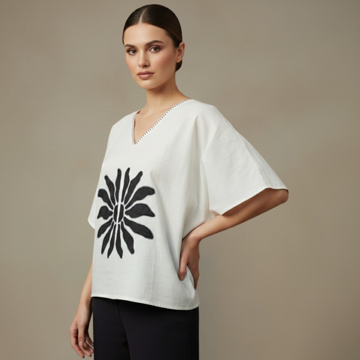Woman wearing a Mangalagiri Cotton white top with a black floral design on a beige background with hands on hip by almitra minimals